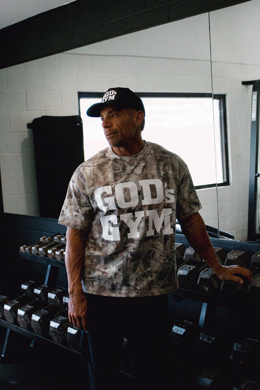 Man wearing the God's Gym Faded Camo Tee in the gym