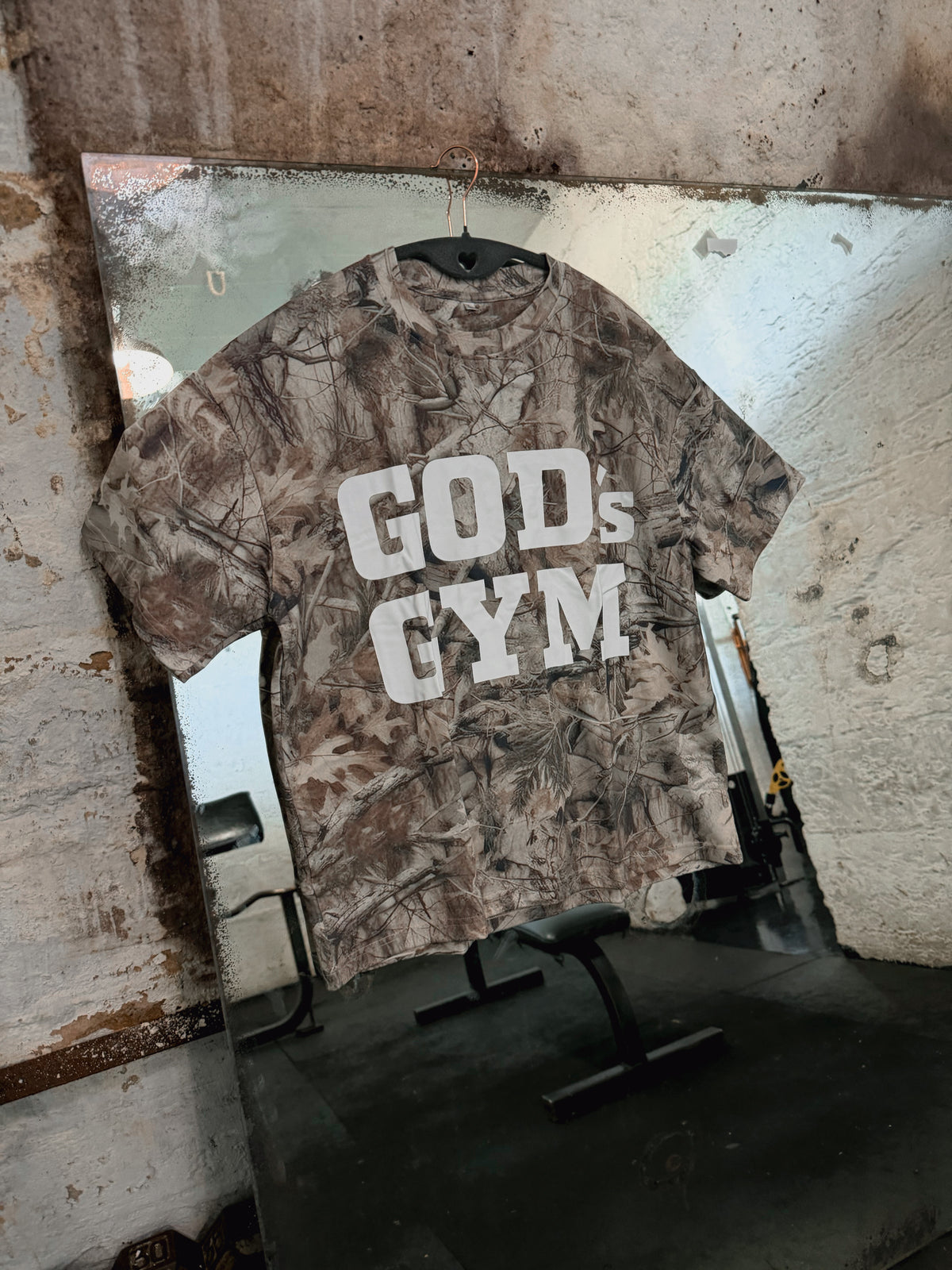 God's Gym Faded Camo Tee hanging on a gym mirror